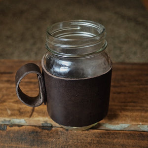 This leather cup sleeve is reusable, sustainable and classy. Stitch with love. Fit Masson jars 16oz.  Ready for a coffee to go?  An all-leather handle for wide mouth 16oz mason jars. Made of 4-5 oz full grain leather in vegtan anniline italian leathe. Riveted with antique brass toned rivets, and no small pieces to wear out and break so this will last a lifetime.