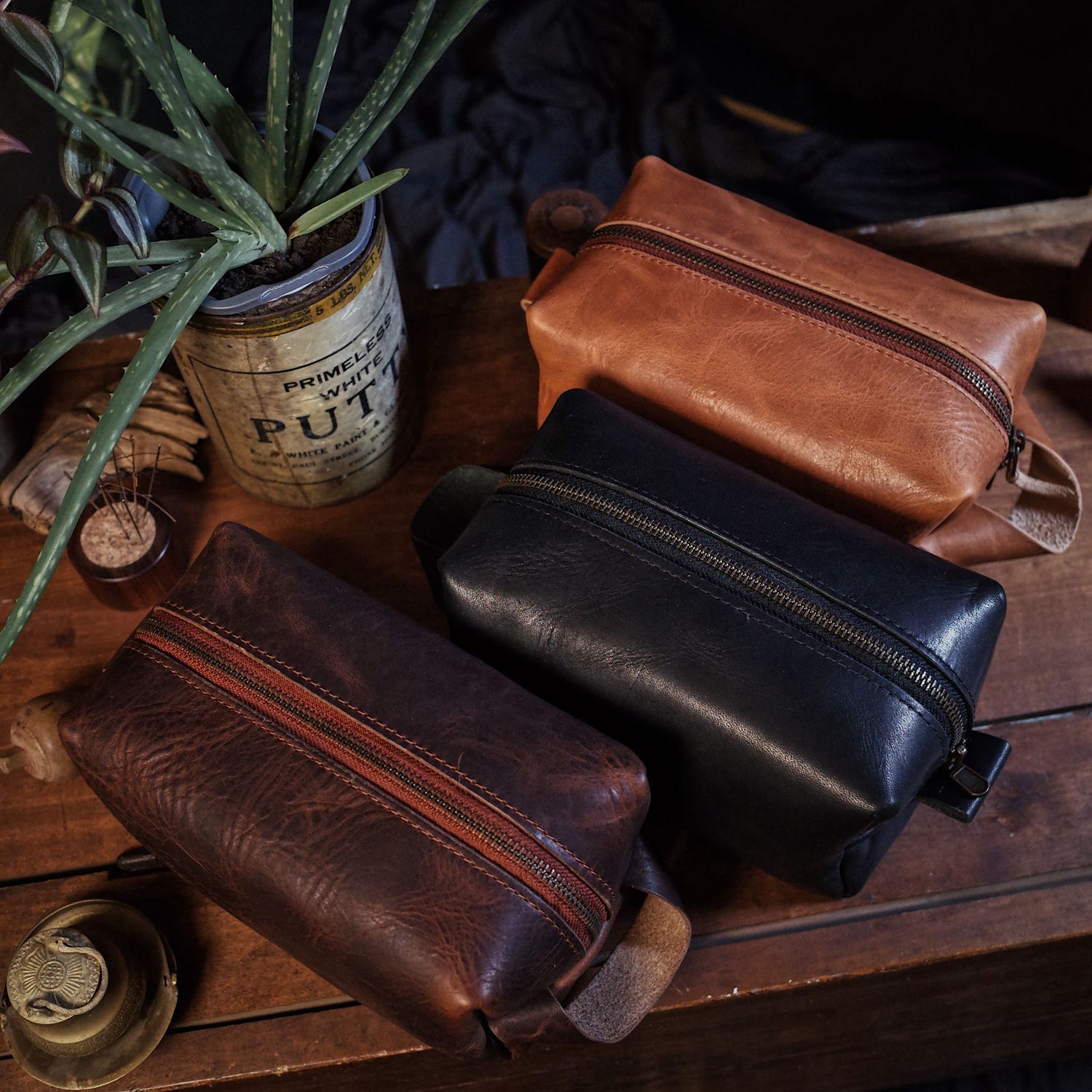 Collection of handcrafted full-grain leather accessories, including belts, toiletry bags, and key holders, made in Montreal with durable materials and timeless design