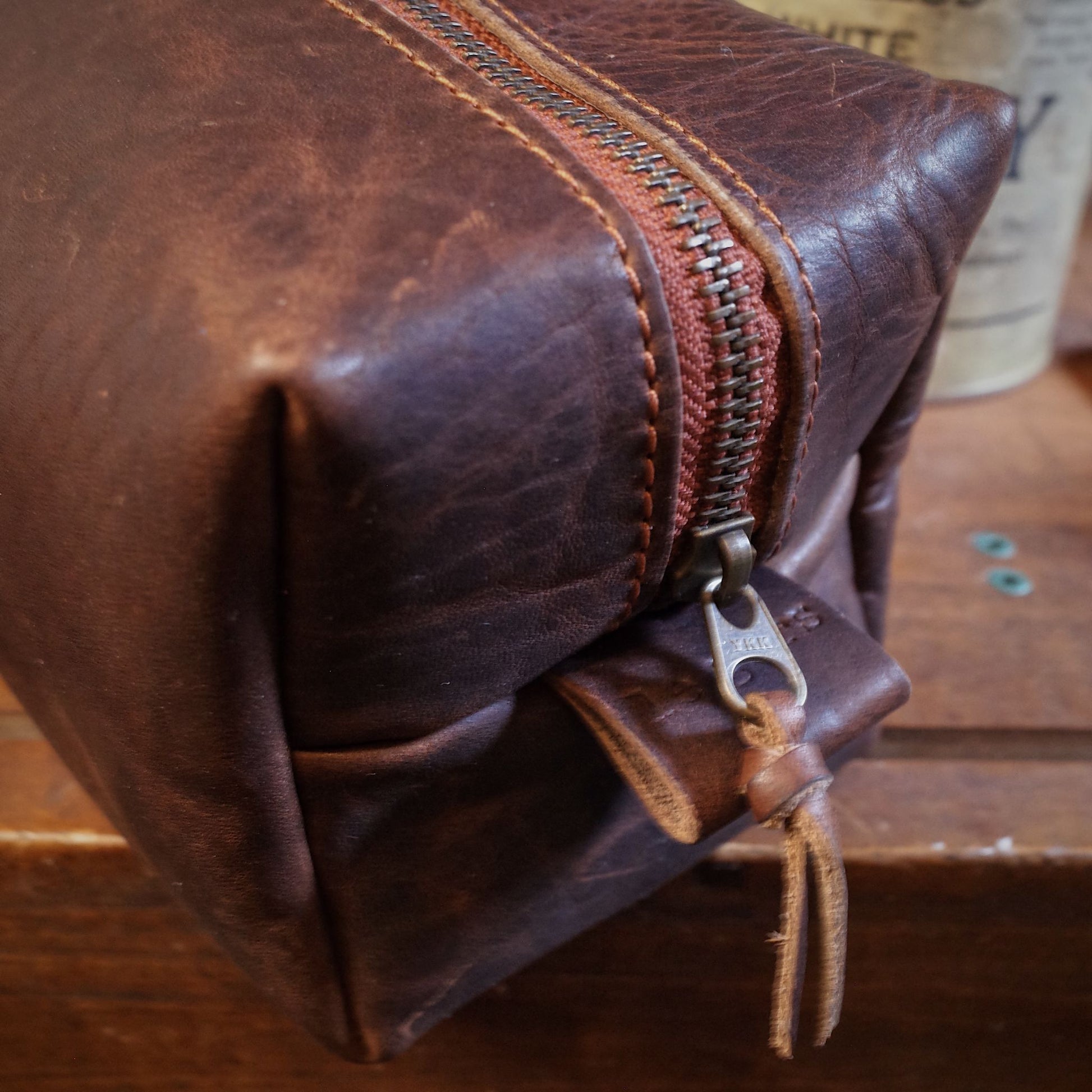 Customizable dark-brown leather dopp kit with durable brass zipper
