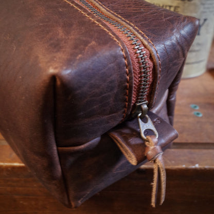 Customizable dark-brown leather dopp kit with durable brass zipper
