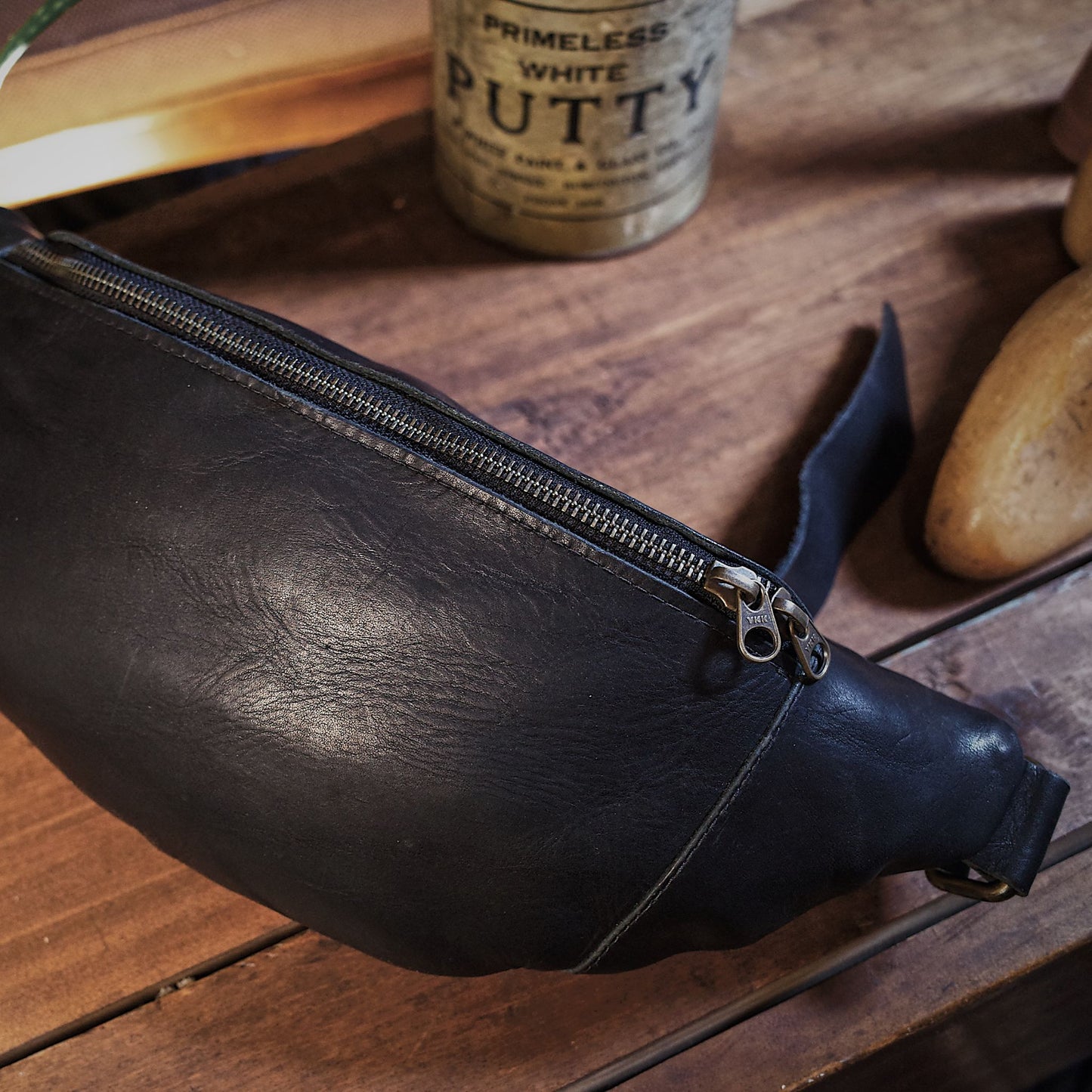 Large black leather belt bag for carrying oversized items
