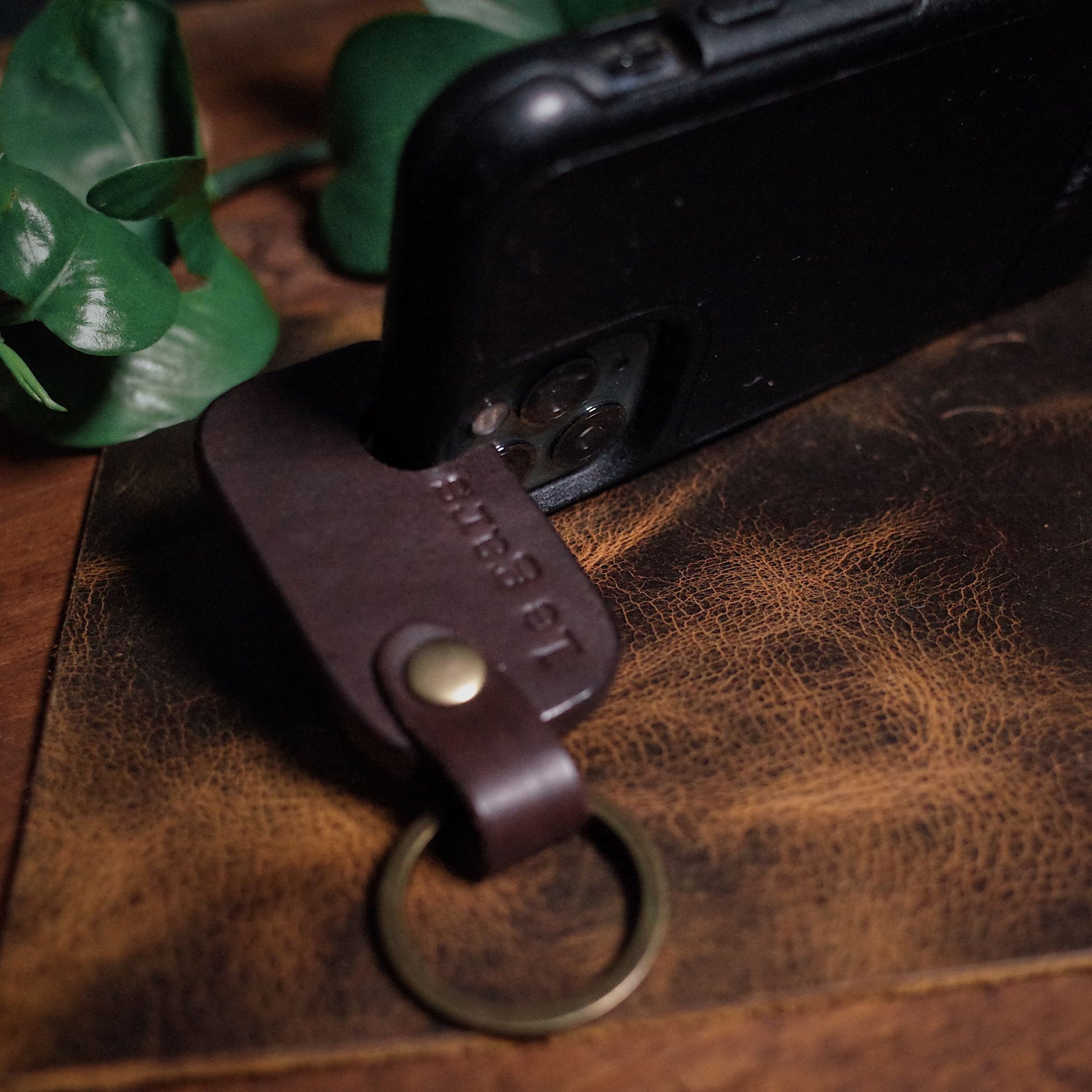 Artisanal dark-brown leather phone holder key fob for easy access

