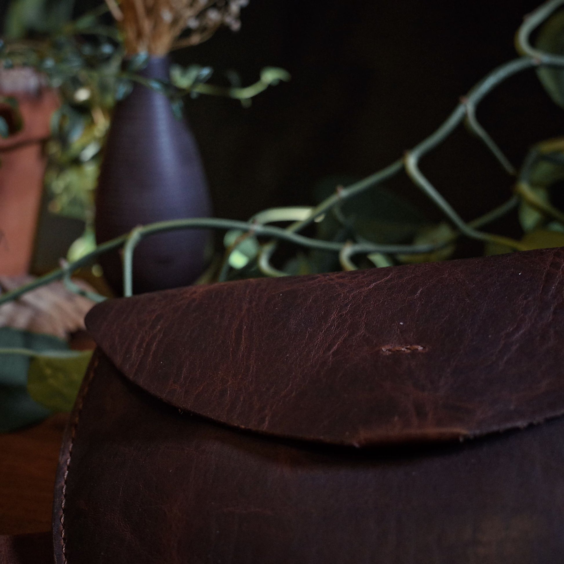 Compact dark-brown leather moon bag with adjustable strap
