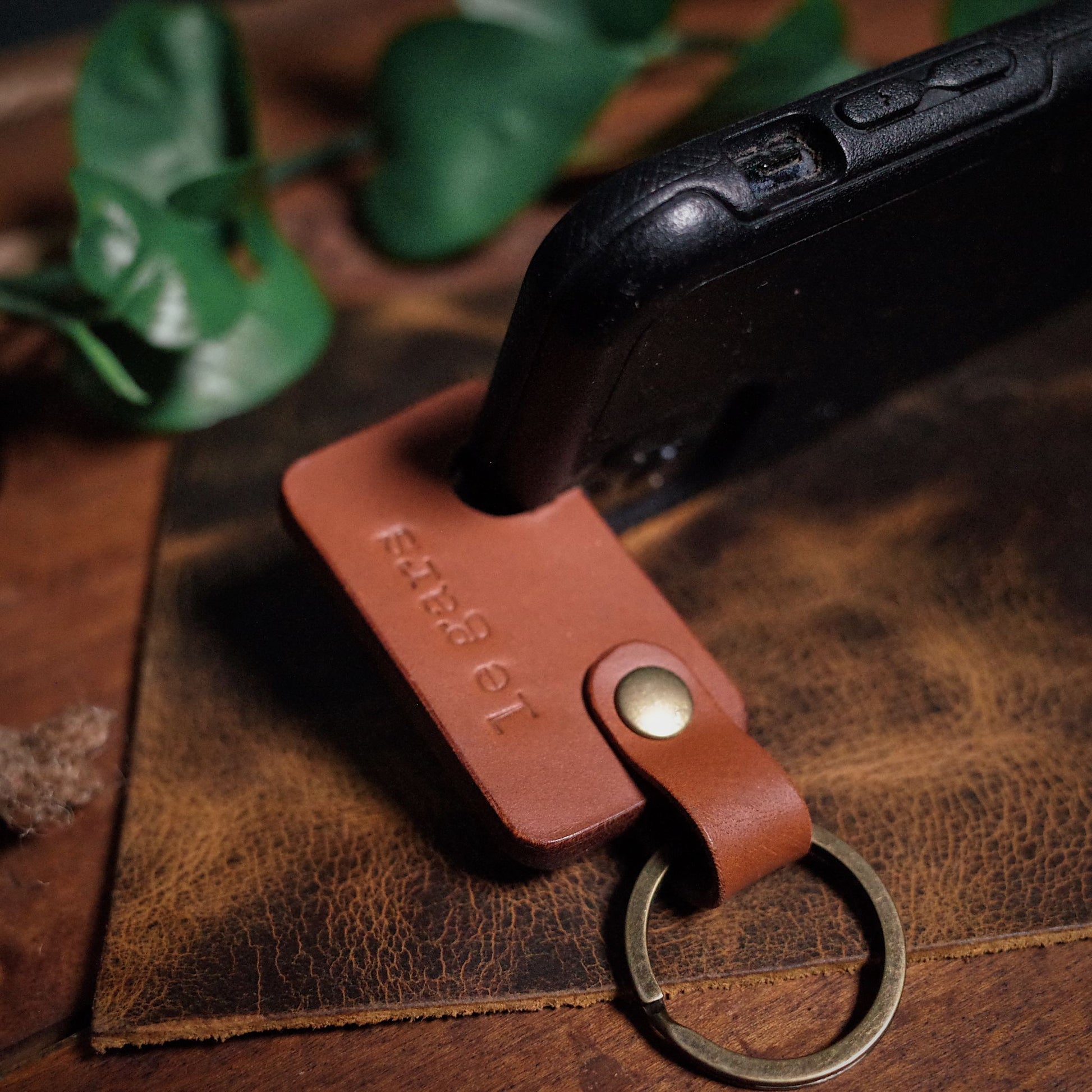 Compact English tan leather key fob phone holder for easy device access
