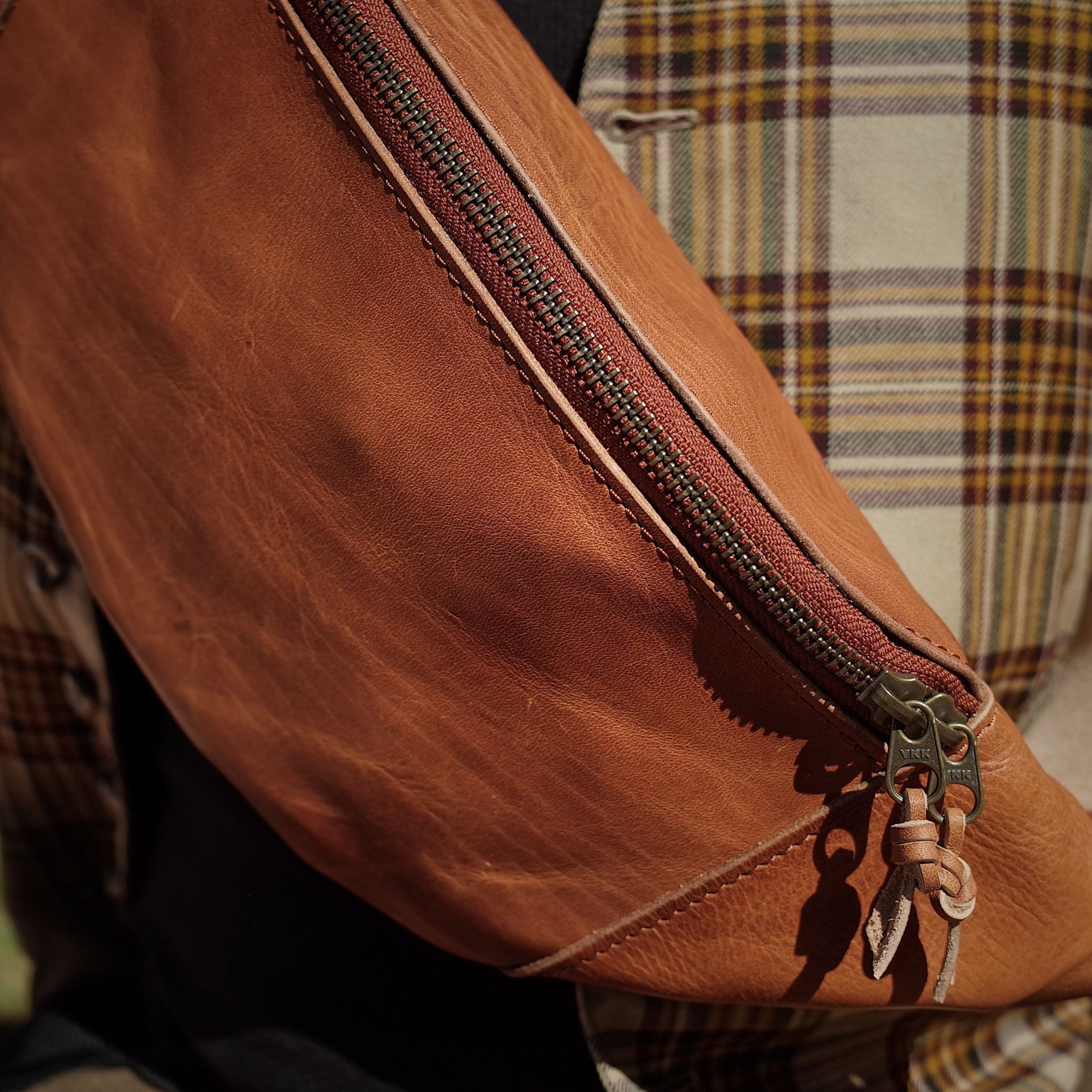 Roomy cognac leather belt bag with secure zipper
