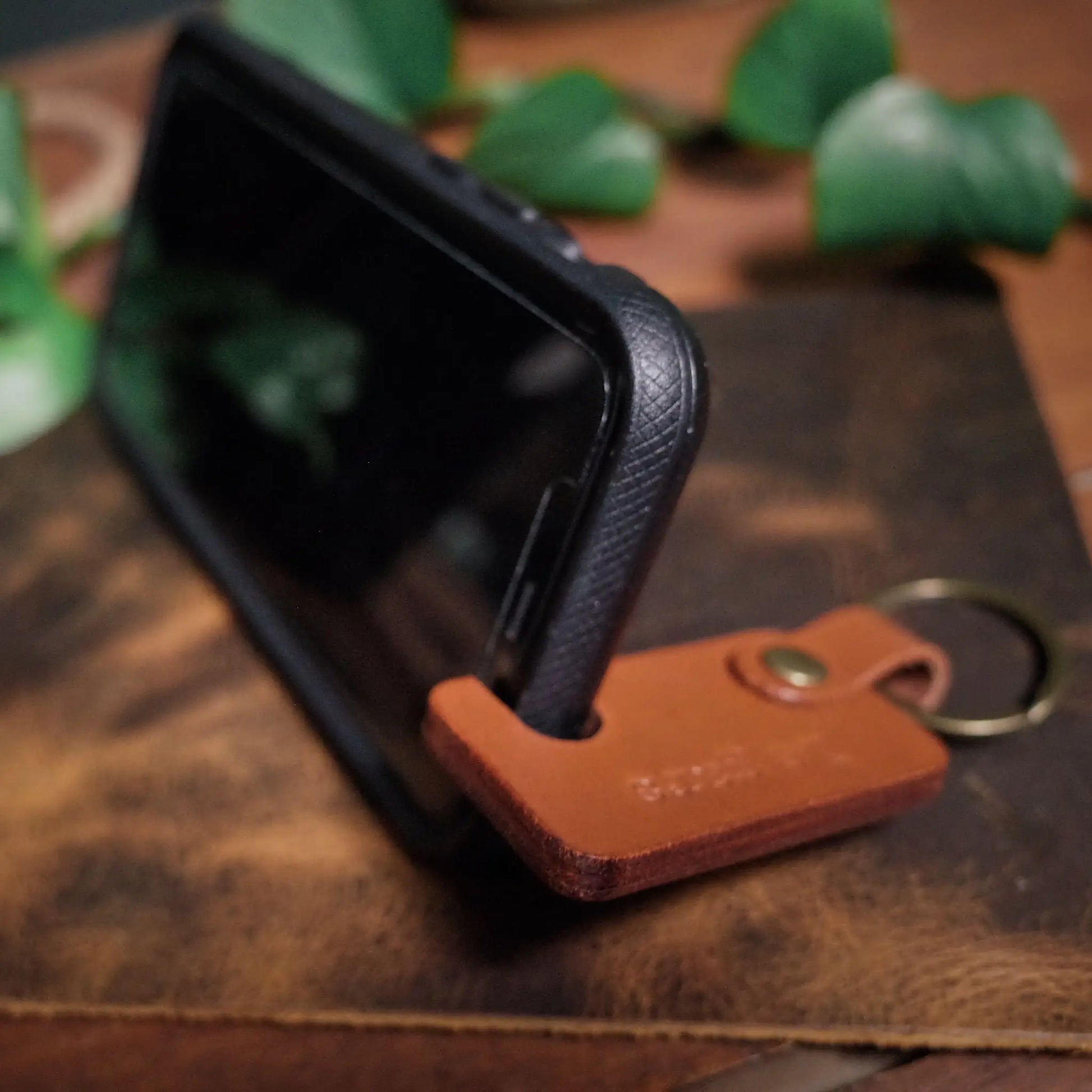 Minimalist caramel leather phone holder with key loop for everyday use
