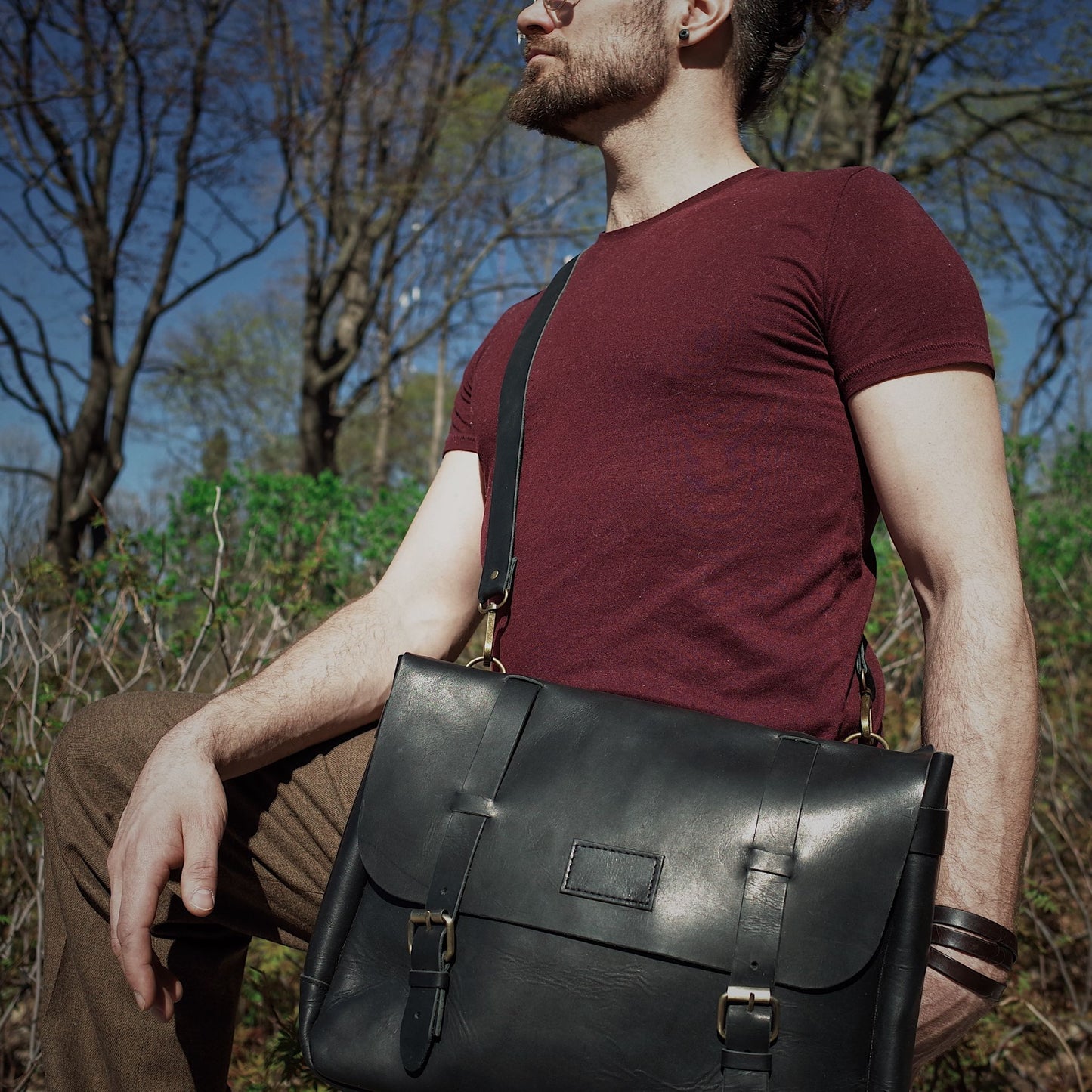 Spacious black leather messenger bag with adjustable shoulder strap
