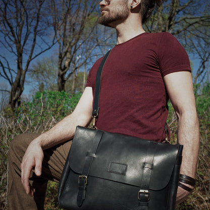 Spacious black leather messenger bag with adjustable shoulder strap
