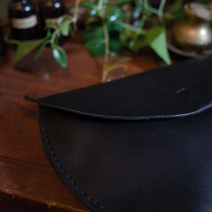 Compact black leather belt bag for hands-free party carry
