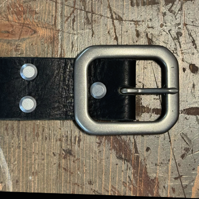 Belt with a silver buckle on a textured background