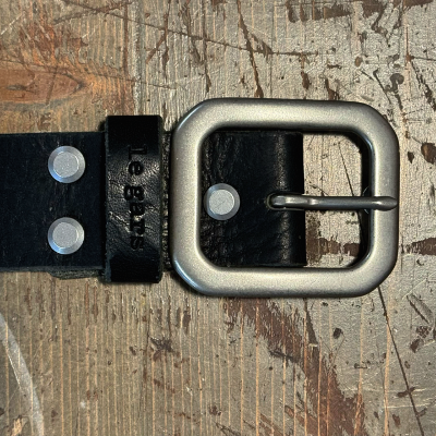 Black belt with silver buckle on a textured surface