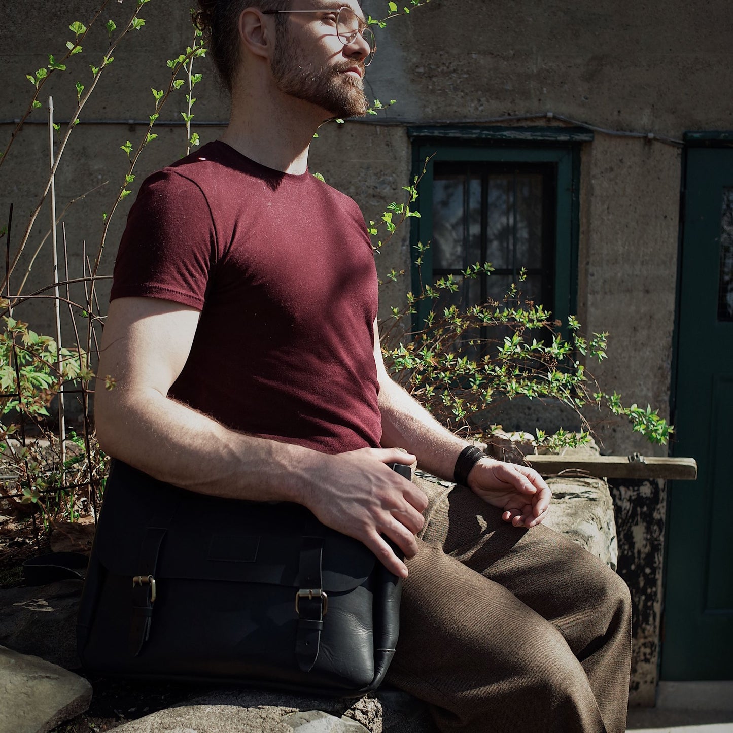 Hand-stitched black leather bag with multiple compartments
