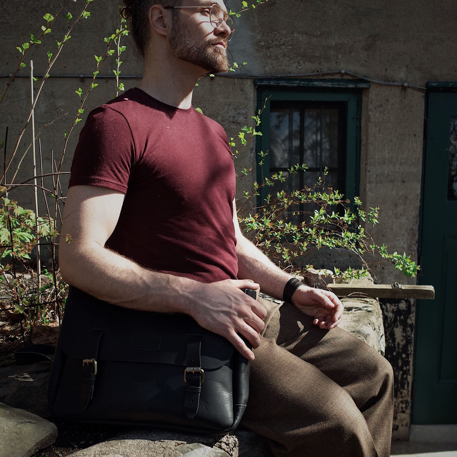 Hand-stitched black leather bag with multiple compartments
