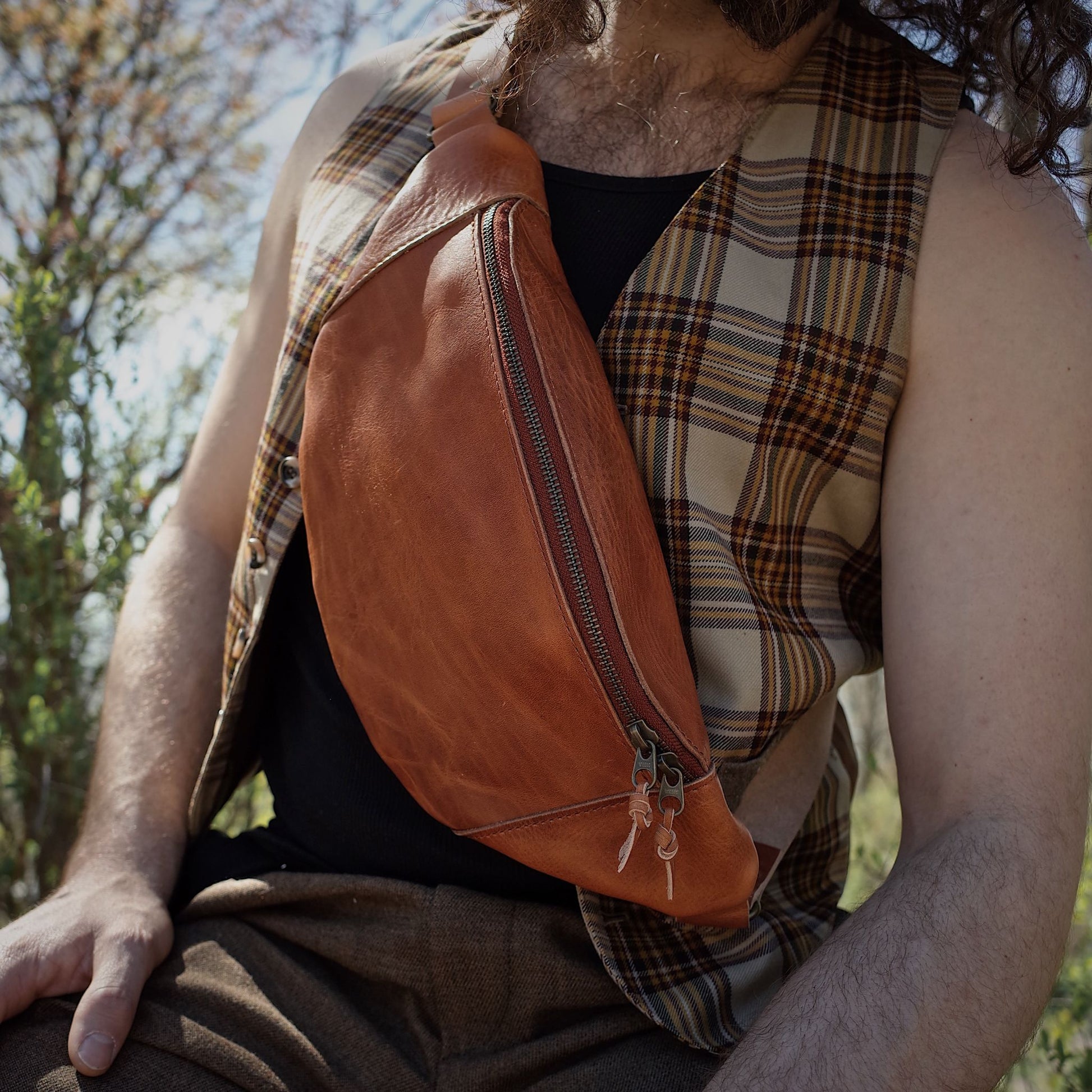 Large saddle tan leather waist bag with durable metal zipper
