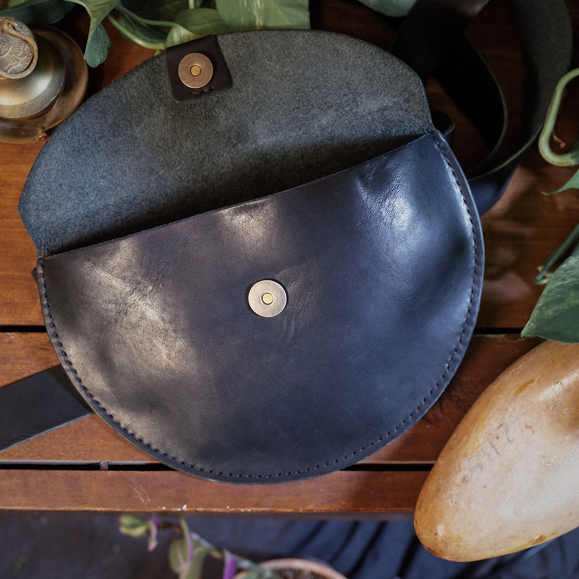 Minimalist black leather fanny pack designed for small essentials

