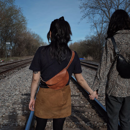 Sleek caramel leather moon bag for carrying essentials at events
