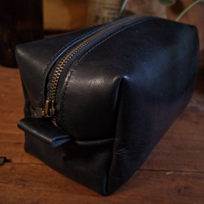 Full-grain black leather travel bag with reinforced zipper for security
