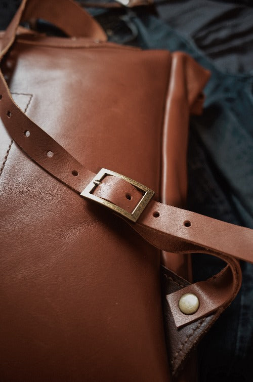 Spacious English tan leather roll-top backpack for everyday carry
